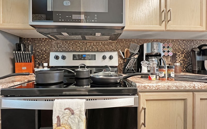 A kitchen with a stove , dishwasher , and microwave.