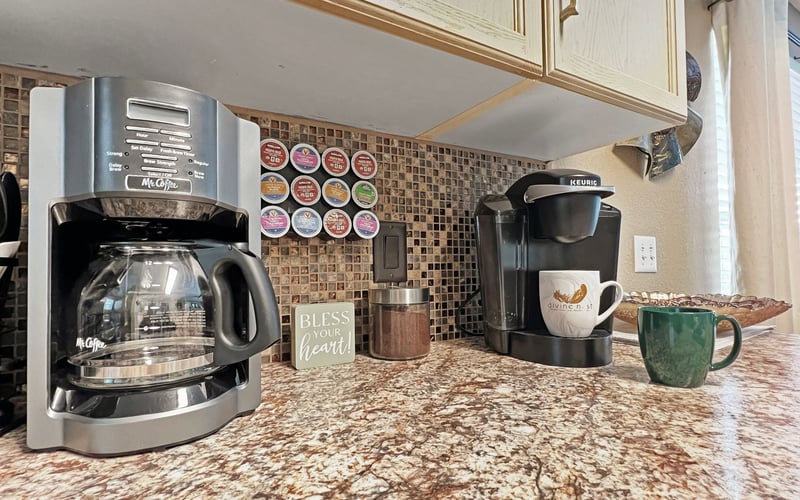 A coffee maker and a keurig coffee maker are on a kitchen counter.