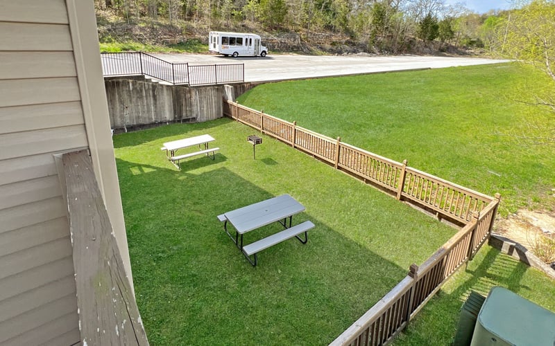 An aerial view of a picnic area with tables and benches in the grass.