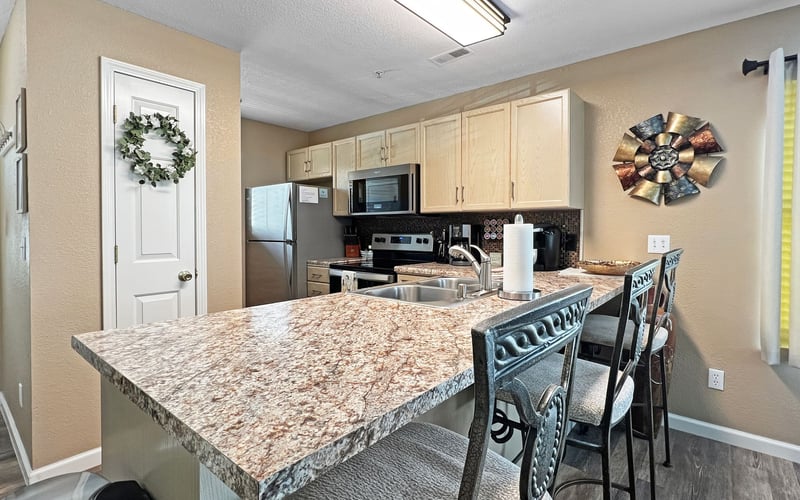 A kitchen with granite counter tops and stainless steel appliances.