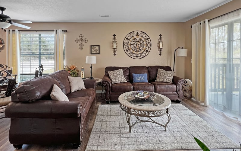 A living room with a couch , coffee table , and sliding glass doors.