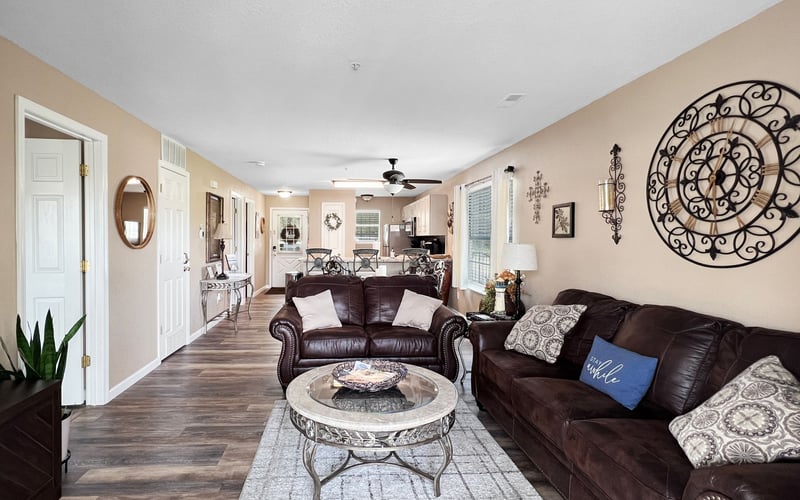 A living room with two couches , a coffee table , and a ceiling fan.