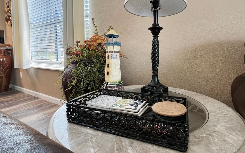 A lamp and a tray are on a table in a living room.
